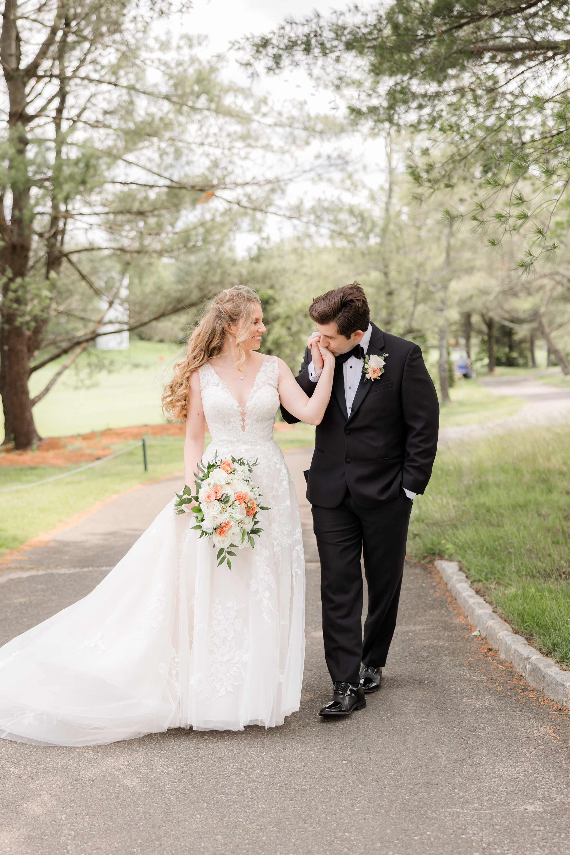 Groom kissing the bride's hand while walking